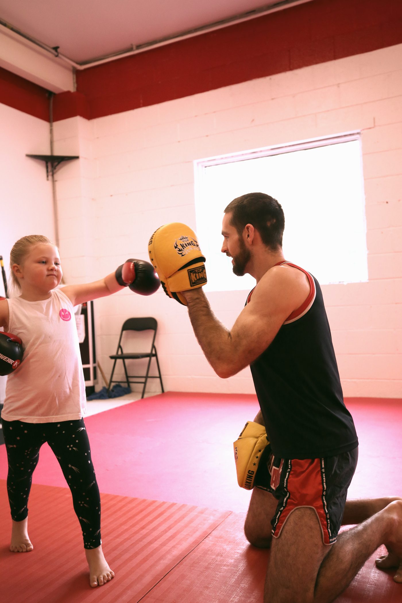 Coach holding pads for a young student