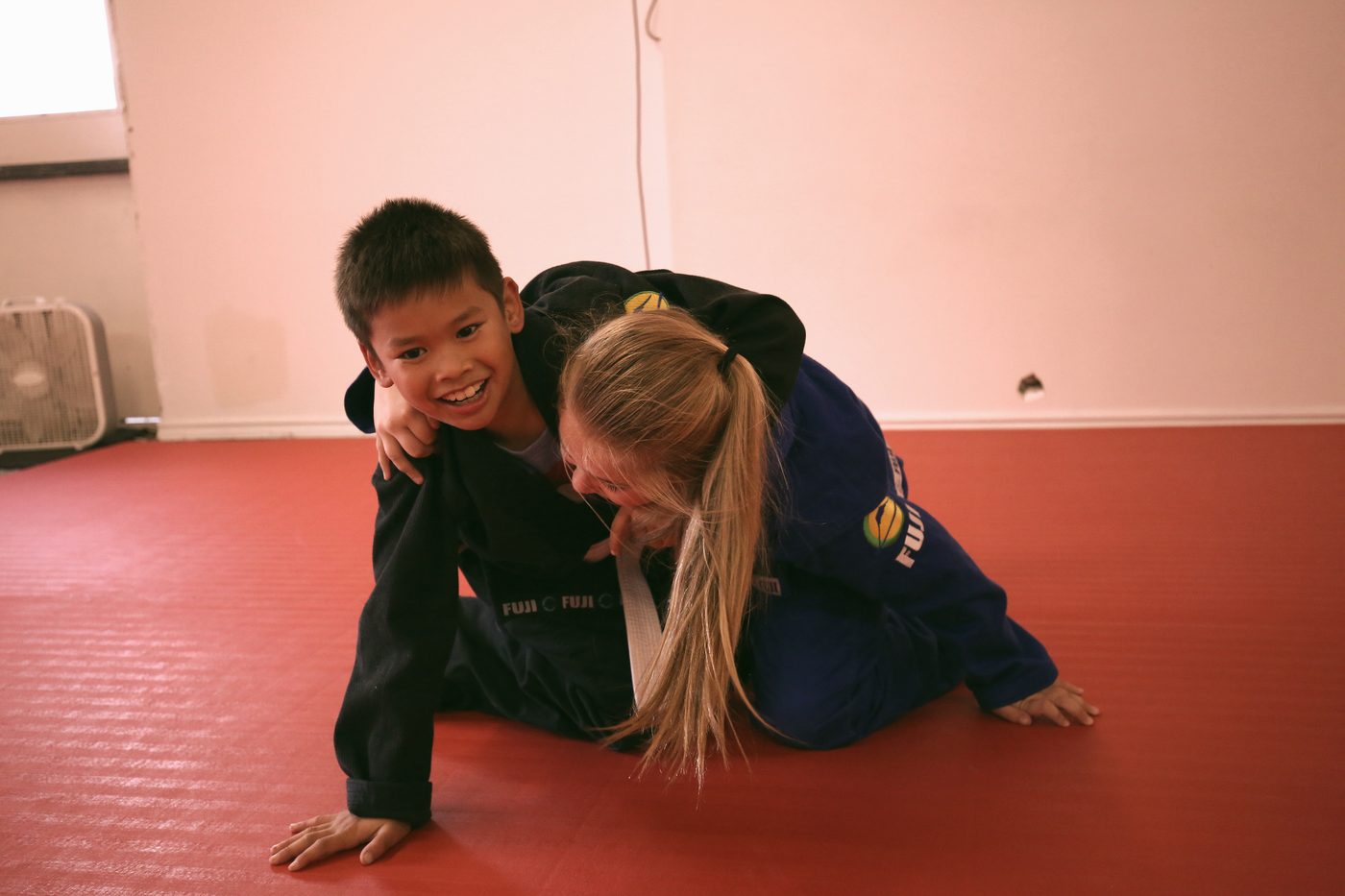 Kids smiling while learning jiu-jitsu